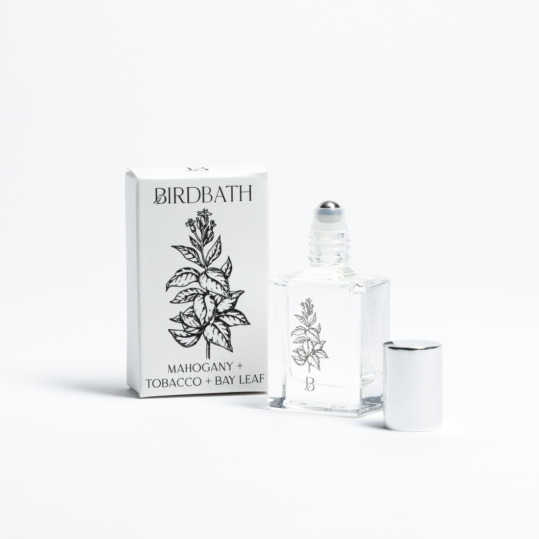 Birdbath Mahogany + Tobacco + Bay Leaf Roll-on Perfume bottle with packaging on a white background.