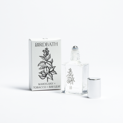 Birdbath Mahogany + Tobacco + Bay Leaf Roll-on Perfume bottle with packaging on a white background.