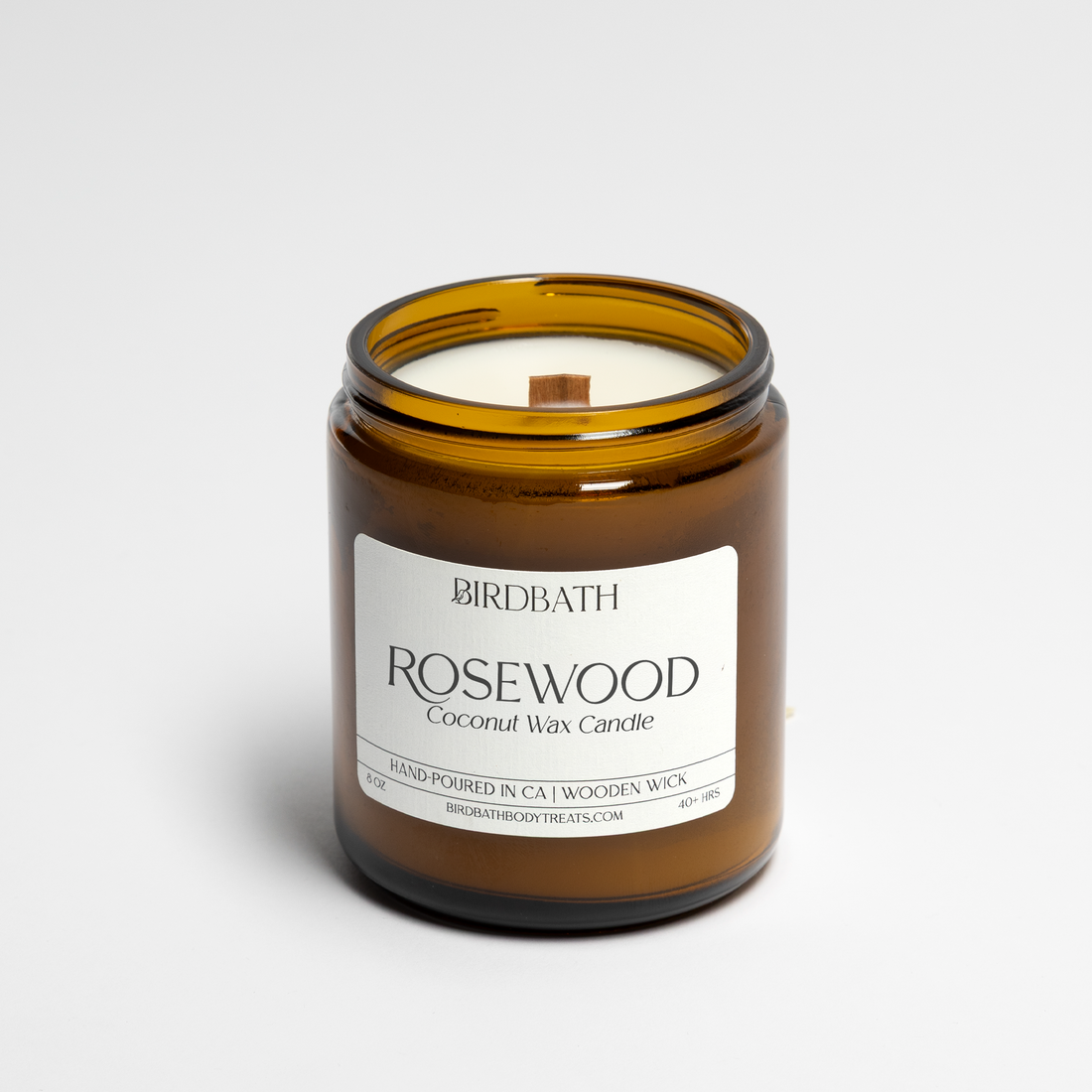 Rosewood Amber glass candle with a label on a white background
